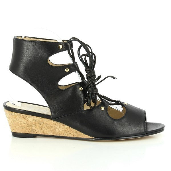 A pair of Amalfi Mille Black Wedges is showcased against a minimalistic background. The wedges feature a sleek black leather upper with an open ankle and front design, laced up with thin black laces. The 3.5cm heel-platform adds a subtle lift, while the durable synthetic sole is visible, emphasizing the shoe's sturdy construction. The clean lines and sophisticated design of these women's shoes highlight their elegant yet modern appeal, making them perfect for various outfits and occasions.