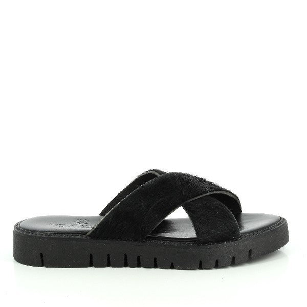 A pair of Antichi Romani 179 Black Cross-Strap Slides is displayed against a neutral backdrop. The slides feature sleek black leather straps crossing over the foot in a sophisticated design. The 3 cm heel adds a subtle lift, while the round toe offers a classic and comfortable fit. The leather upper and lining highlight the fine Italian craftsmanship, and the synthetic sole ensures durability.