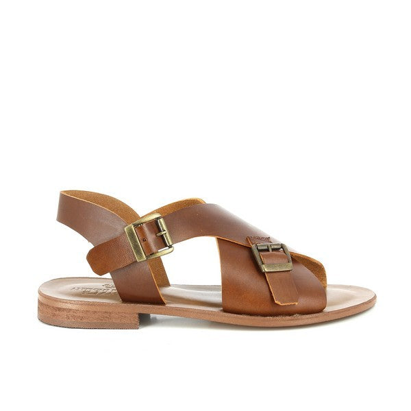 A detailed view of the Antichi Romani 2039 Cuoio Slingback Sandals. The image highlights the rich cuoio leather upper with a stylish cross-strap design and decorative golden buckles at the front. The adjustable slingback strap ensures a secure fit, while the 2 cm heel provides a subtle lift. The round toe shape is visible, adding to the sandal’s classic appeal. The soft leather lining is evident, emphasizing comfort, and the lightweight synthetic sole contrasts with the leather upper, showcasing durability.