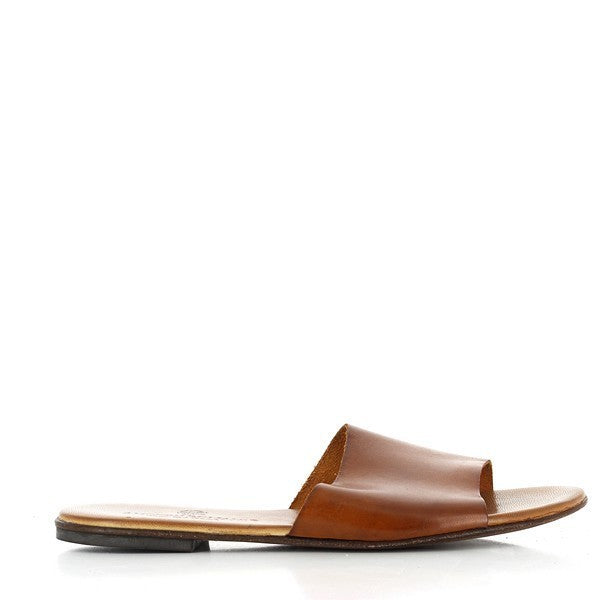 The photo features the Antichi Romani 525 Tan Slides, elegantly displayed to highlight their minimalist design. Crafted from high-quality tan leather, the slides showcase a smooth finish that emphasizes their premium quality. The classic round toe adds a timeless appeal, while the 1cm heel offers a subtle lift for added comfort. The leather lining is visible, indicating the luxurious feel against the skin. Set against a neutral background, the sandals exude effortless style.