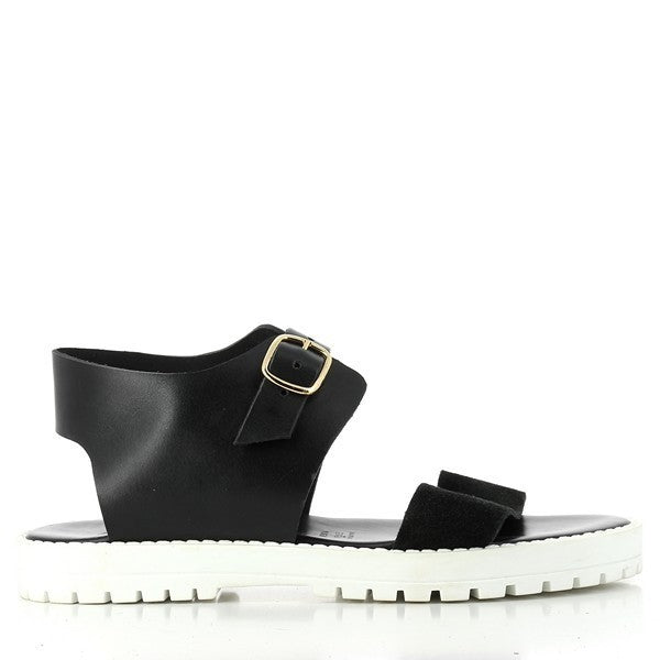 The Antichi Romani 861 Black Slingback Sandals are elegantly displayed from the side, showcasing their sleek and sophisticated design. The premium black leather upper glistens softly under the light, highlighting its rich texture and quality craftsmanship. The round toe adds a classic touch, while the 2cm heel offers a subtle lift. The adjustable slingback strap is positioned for comfort, demonstrating the attention to detail in the design.