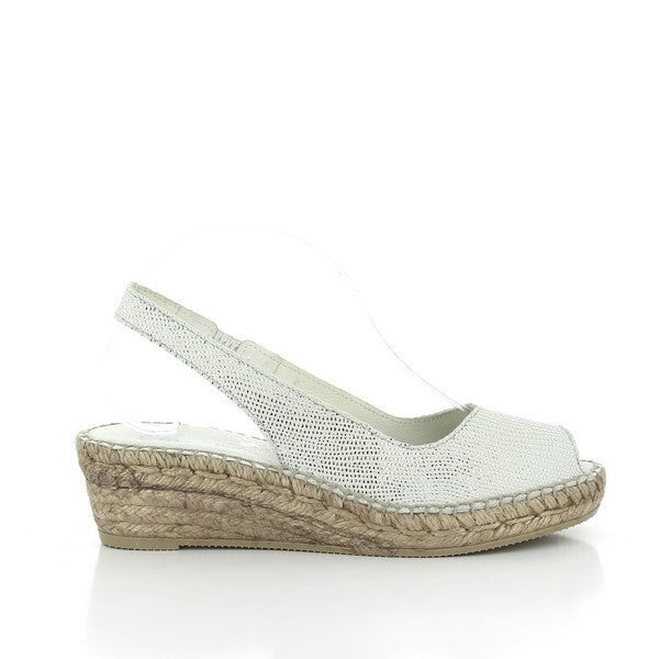 The photo showcases the Calzanor 1536 White Slingback Espadrilles, elegantly arranged on a neutral background. The espadrilles feature a sleek white leather upper with a rounded toe and a stylish slingback strap, offering a comfortable fit. The espadrilles are perched on a natural jute sole, emphasizing their handcrafted quality. Sunlight gently highlights the texture of the leather and the intricate stitching, reflecting the craftsmanship that goes into each pair.