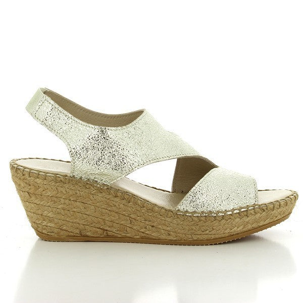 The image showcases the Calzanor 2042 Gold Slingback Espadrilles beautifully arranged on a light, textured surface. The shimmering gold leather upper catches the light, creating a radiant effect that highlights the shoe's luxurious finish. The sleek slingback strap wraps around the heel, ensuring a secure fit, while the soft leather lining is subtly visible at the opening. The natural jute-wrapped sole contrasts elegantly with the gold, emphasizing the artisanal craftsmanship.
