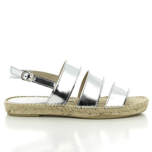 The Calzanor 2044 Silver Slingback Espadrilles are elegantly displayed, showcasing their shimmering silver leather upper that catches the light. The slingback design features a soft strap for a secure fit, while the round toe adds a classic touch. The natural jute sole is visible, highlighting the espadrilles' handcrafted quality and eco-friendly appeal. With a subtle 1 cm platform, these espadrilles exude both style and comfort, making them ideal for various summer occasions.