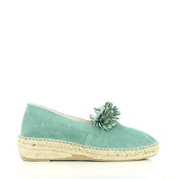 The Calzanor 2045 Turquoise Espadrilles are beautifully displayed, highlighting their vibrant color and intricate design. The closed style features a rich turquoise leather upper, accented by decorative flowers that add a charming and playful touch. The espadrilles showcase a round toe shape, offering a roomy fit while maintaining elegance.