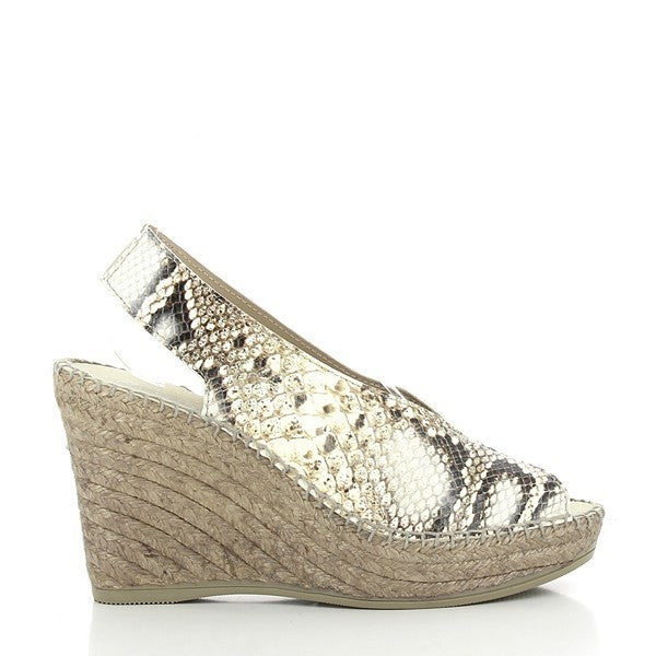 A pair of Calzanor 2214 Gold Slingback Espadrilles elegantly displayed on a simple, light-colored backdrop. The shoes feature a shiny gold leather upper with a slingback strap and a chic peep toe design. The jute-wrapped platform heel adds natural texture, highlighting the craftsmanship. The warm gold tone contrasts beautifully with the woven jute sole, giving the espadrilles a luxurious yet earthy feel. Perfect for casual or dressy occasions, the shoes exude both glamour and comfort.