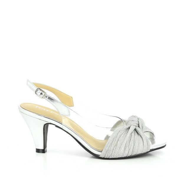 The photo showcases a pair of Dalessi Dabble Silver Slingback Heels, featuring a sleek metallic silver upper that gleams in the light. The peep-toe design offers a stylish, open-front look, while a decorative front knot adds a chic and feminine touch. Transparent side panels enhance the contemporary design, providing a light, airy effect. The slingback strap secures the shoe comfortably around the heel, and the 7 cm heel height offers the perfect lift, blending elegance and comfort.