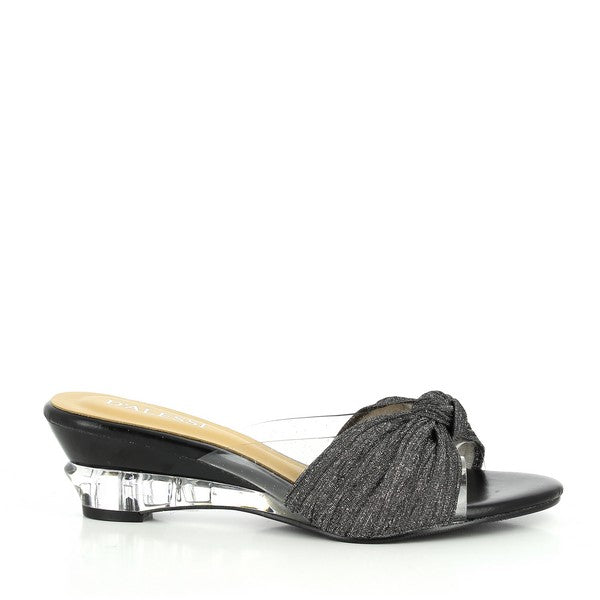 The Dalessi Dresden Black Slide from the side, showcasing the smooth synthetic upper with a subtle curve around the rounded toe. The elegant front knot detail adds a touch of sophistication.