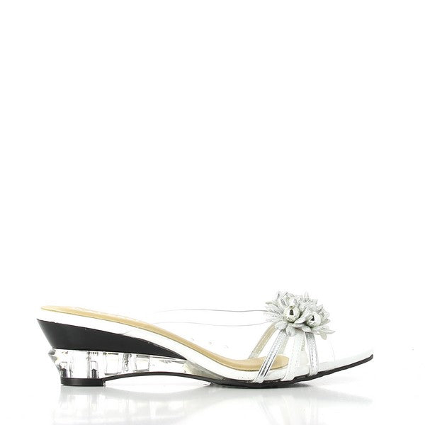 A profile view of the Dalessi Dupont White & Silver Slides, showcasing the sleek leather upper and transparent floral accents. The clean lines of the shoe highlight its modern yet feminine design, while the round toe shape ensures a flattering fit.