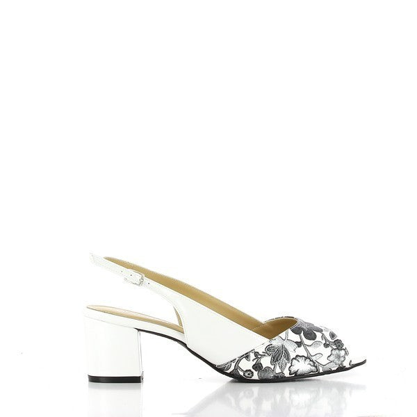 A profile view of the Dalessi Duprey Strips Black & White Slingback Sandals, highlighting the sleek white leather upper with pewter floral details. The rounded toe shape and classic slingback design create a refined, sophisticated silhouette.