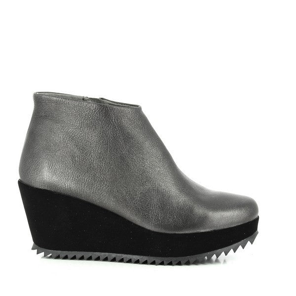 The side view of the Felmini 1100 Black Wedge Booties reveals the smooth, high-quality black leather upper, paired with a sleek 7cm wedge heel. The clean lines and round toe shape offer a stylish, sophisticated look that enhances the overall silhouette.