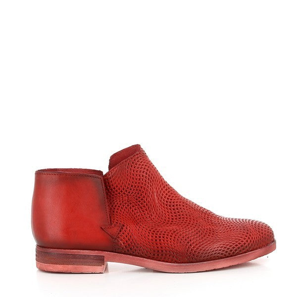 A vibrant red leather bootie showcasing its sleek silhouette, with a gently rounded toe and a 2.5cm low-profile heel. The fine craftsmanship of the smooth leather upper and the seamless stitching details are prominent.