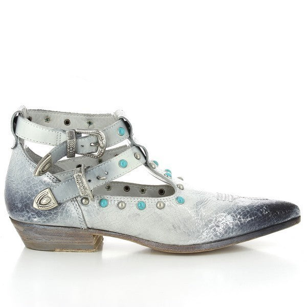 The Forte S17-4212 White Ankle Boots showcase a sleek, pointed-toe design, with two elegant straps featuring cowboy-style buckles. The white leather upper contrasts with the silver and blue studded details, adding a unique, stylish edge to the boots.