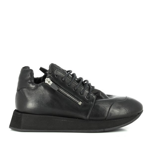 A sleek black sneaker showcasing a premium leather upper with a round toe and clean stitching details. The lateral zippers add a modern touch.
