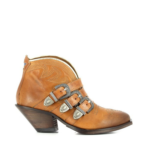 A clear side view of the tan ankle boot showcasing its sleek cowboy-inspired silhouette, three decorative straps with metallic buckles, and a 5 cm stacked heel.