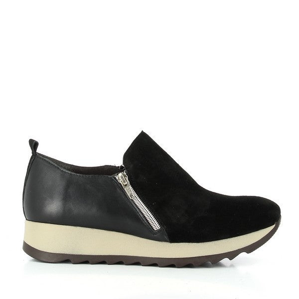 A sleek black sneaker featuring a soft suede upper with a smooth leather panel around the ankle. The external zipper adds a modern touch while ensuring easy slip-on wear.