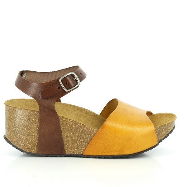 A stylish photo showcasing Plakton's 273104 Mustard & Brown Wedges from their Women's Collection. Handcrafted in Spain, these wedges feature a premium leather upper in mustard and brown tones, an adjustable ankle buckle, and a comfortable cork sole. Perfect for adding a touch of sophistication and comfort to any outfit.