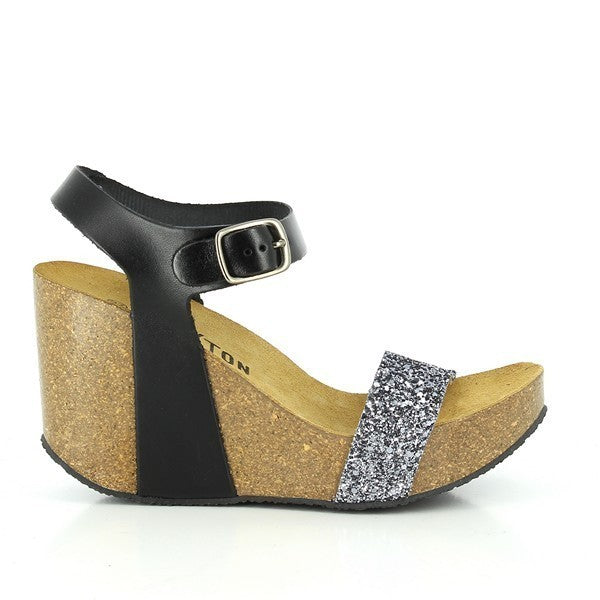 A captivating photo featuring Plakton's 433023 Black Slingback Wedges. Crafted from luxurious black leather with a cork sole, these sandals showcase an adjustable ankle strap for a personalized fit. Perfect for eco-conscious fashionistas seeking style and comfort in every step.