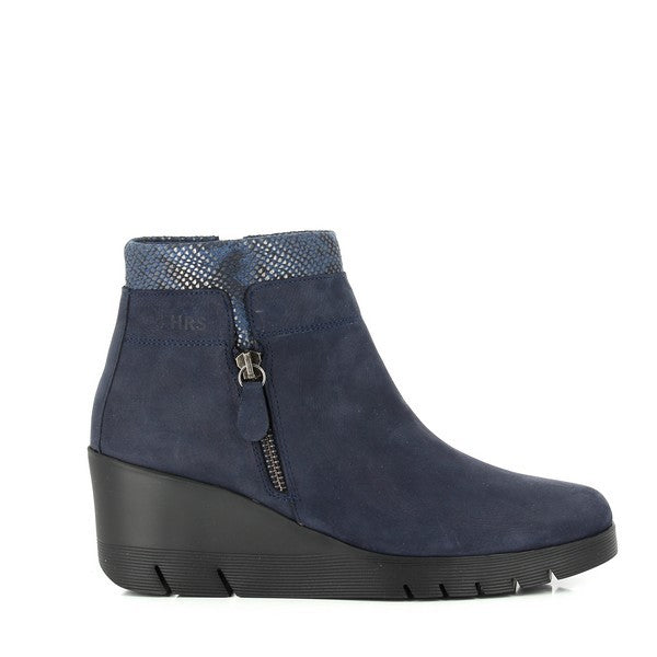 The 24 Hrs 23454 Navy Ankle Boots for women showcase a sleek, modern design with premium navy leather and a rounded toe. Featuring a 6 cm heel-platform, these boots offer a stylish yet comfortable lift. The outside zipper adds convenience, making them easy to slip on and off. Handcrafted in Spain, these boots blend durability with elegance, perfect for any occasion.