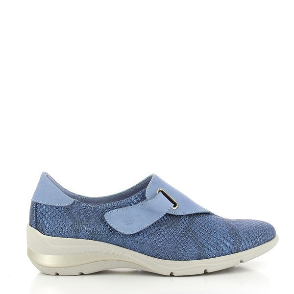 A pair of 24 Hrs 24032 Light Blue Sneakers is placed on a clean white background. The sneakers feature a sleek, modern design with a soft light blue leather upper and a rounded toe shape. A single velcro strap crosses the top, providing a secure fit. The white synthetic sole has a subtle 4.5 cm platform, adding height while maintaining a comfortable, casual look. The sneakers' smooth leather lining peeks out from the top, showcasing the quality craftsmanship. The overall presentation highlights the sneakers