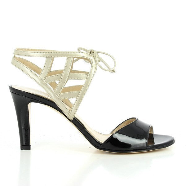 Shows the striking gold and black leather upper, highlighting the sleek design and the 8cm heel. The elegant profile and refined silhouette are emphasised.