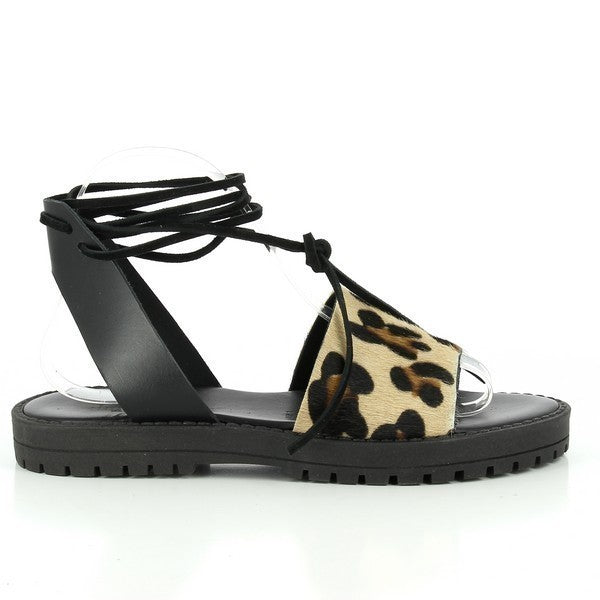 The Antichi Romani 928 Leopard Slingback Sandals are displayed in a beautifully styled setting, highlighting their elegant design. The upper features a striking leopard print, crafted from high-quality leather that exudes luxury. The adjustable slingback strap is showcased, emphasizing the comfortable fit tailored for slender feet. The sandals rest on a soft surface, with the 2cm heel-platform height clearly visible, illustrating the perfect blend of style and comfort. 
