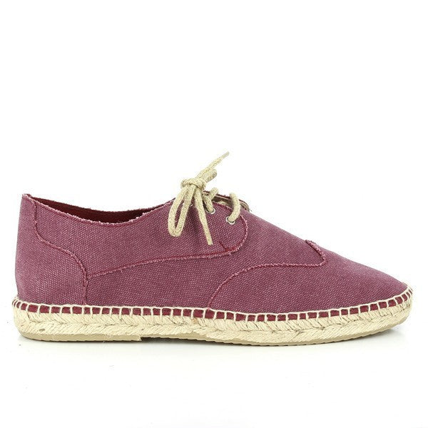 The photo showcases a pair of Calzanor 1982 Burgundy Lace-Up Espadrilles, highlighting their elegant and stylish design. The rich burgundy leather upper features a smooth finish, accented by a classic lace-up closure that adds a touch of sophistication. The hand-stitched jute sole exhibits a natural texture, emphasizing the eco-friendly craftsmanship. These espadrilles have a comfortable round toe and a subtle 2 cm platform, offering a slight lift without compromising on comfort. 