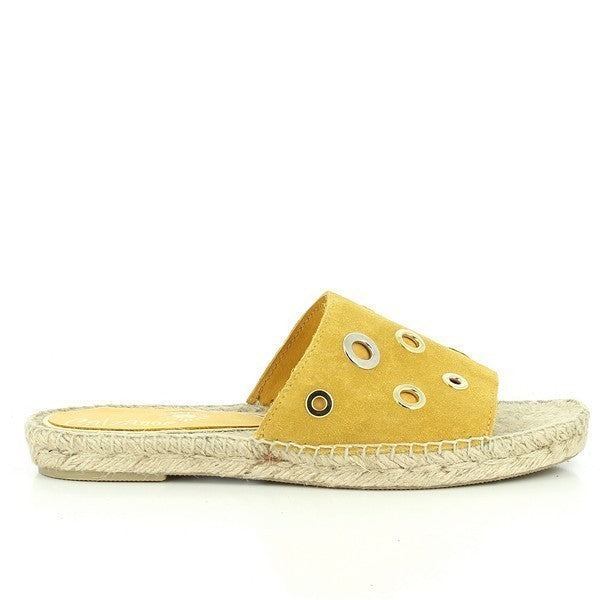 The photo features a pair of Calzanor 2012 Mustard Slide Espadrilles, showcasing their vibrant and stylish design. The upper is made of soft mustard leather, exuding a cheerful and summery vibe. The espadrilles are slip-on style, allowing for easy wear, while the round toe shape provides comfort and a relaxed fit. The hand-stitched jute sole is visible, highlighting the eco-friendly craftsmanship and natural texture. 