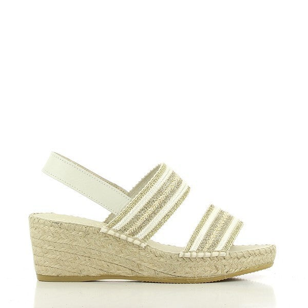 A pair of Calzanor 2051 White & Gold Slingback Espadrilles is elegantly displayed against a neutral background. The white leather upper, accented with subtle gold detailing, adds a touch of sophistication to the design. The rounded toe and sleek slingback strap give the espadrilles a balanced and comfortable look. The 6.5 cm jute platform sole, hand-stitched with care, showcases the natural fibers, adding texture and highlighting the eco-friendly craftsmanship. 