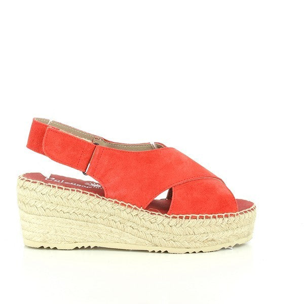 A pair of Calzanor 2135 Red Slingback Espadrilles is displayed against a light, summery background. The vibrant red leather upper catches the eye, contrasted by the natural beige jute sole. The slingback strap sits elegantly at the heel, while the 7cm platform gives the shoes a slight lift. The rounded toe shape complements the laid-back yet stylish look, and the intricate hand-stitching along the edges highlights the craftsmanship. 