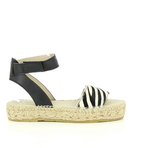 A pair of Calzanor 2233 Black & White Slingback Espadrilles elegantly arranged on a soft, neutral background. The shoes showcase a striking black and white leather upper, featuring a stylish slingback strap and a round toe design that exudes modern sophistication. The jute-wrapped 4cm platform heel adds a natural touch, highlighting the handcrafted quality and attention to detail. The overall aesthetic is chic and versatile, making these espadrilles a perfect choice for both casual and dressier outings.