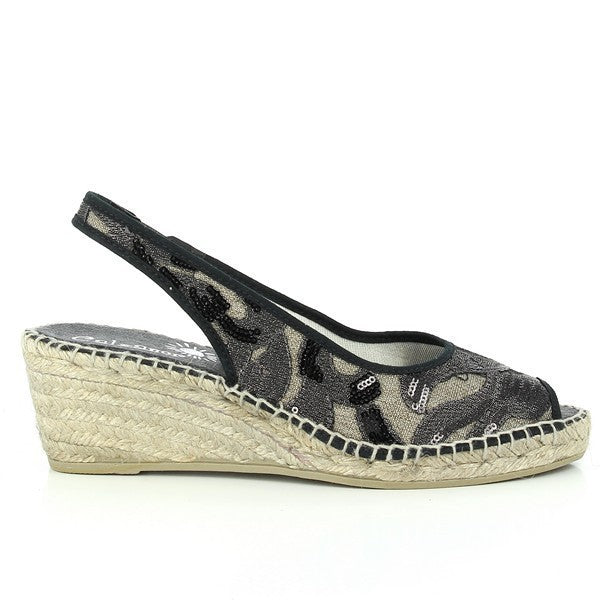 A pair of Calzanor 224 Black Slingback Espadrilles is elegantly displayed against a soft, neutral backdrop. The espadrilles feature a sleek black leather upper, showcasing a stylish peep-toe design that adds a modern touch. The slingback strap offers a secure fit, while the 5cm heel-platform enhances the silhouette without sacrificing comfort. The eco-friendly synthetic sole peeks out, hinting at the shoes' durability and flexibility. 
