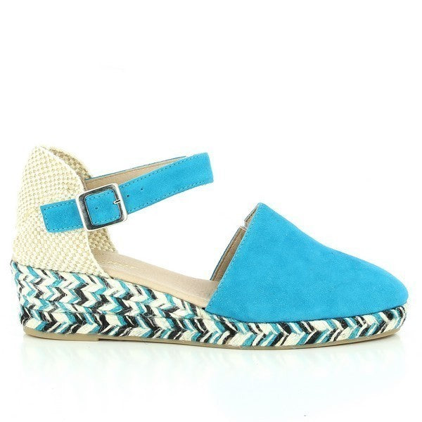 The photo showcases the Calzanor 8880 Turquoise Slingback Espadrilles, beautifully displayed against a neutral background. The vibrant turquoise leather upper gleams in the light, highlighting its soft texture and rich color. The espadrilles feature a rounded toe shape and a stylish slingback design, with a delicate ankle strap that adds elegance. The eco-friendly jute sole is visible, demonstrating its natural fiber and hand-stitched craftsmanship. 
