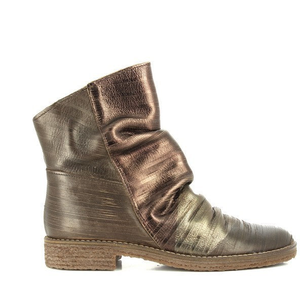 The sleek dark brown leather ankle boot showcases its smooth, wrinkled texture with a rounded toe. The clean lines and simple design highlight the boot’s versatile and timeless appeal.