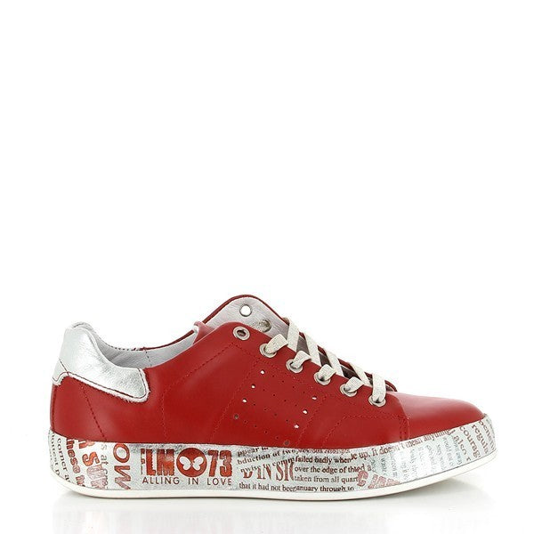 A clear view of the Felmini B153 red sneaker from the side, showcasing the smooth leather upper in a vibrant red hue. The rounded toe and sleek silhouette offer a modern and stylish look, with the contrasting silver sole adding a touch of elegance.
