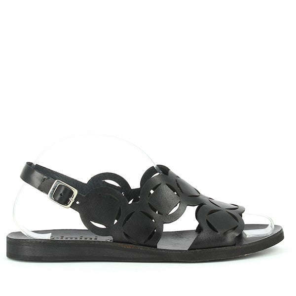 A clear side shot of the sandal highlighting the sleek black leather upper, decorative circular shapes, and ankle strap with a small silver buckle for fastening. The sandal’s low heel and minimalist design are prominently visible.