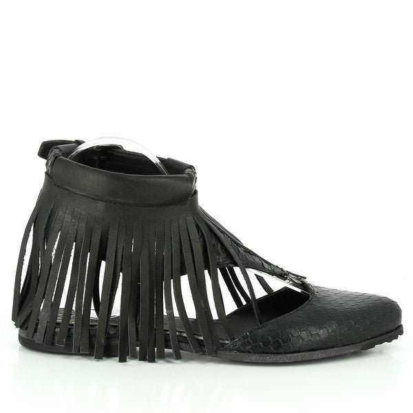 A sleek black sandal with a pointed closed front, long decorative fringes cascading from the upper, and an adjustable ankle buckle.