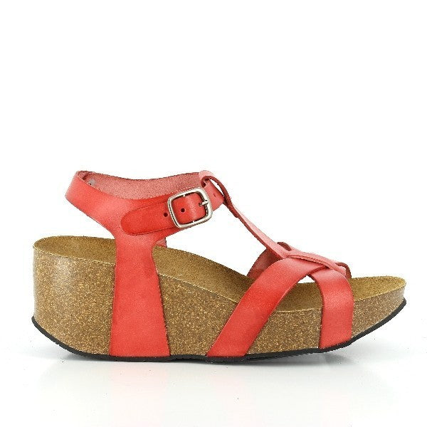 A close-up image showcasing the side profile of Plakton's 273015 Orange Wedges. The vibrant orange leather upper contrasts beautifully with the natural cork sole. The unique cross-band design and adjustable buckle strap are visible, highlighting the sandal's stylish and functional elements.