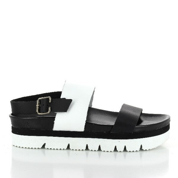 A stylish photo showcasing Plakton's 465167 White & Black Slingback Platforms. These women's sandals feature elegant white and black leather slingback straps, a 5 cm platform heel, and a synthetic sole with a cork base. The design includes a round toe shape and an adjustable slingback strap with a buckle for a secure fit. Perfect for modern, eco-conscious fashionistas.